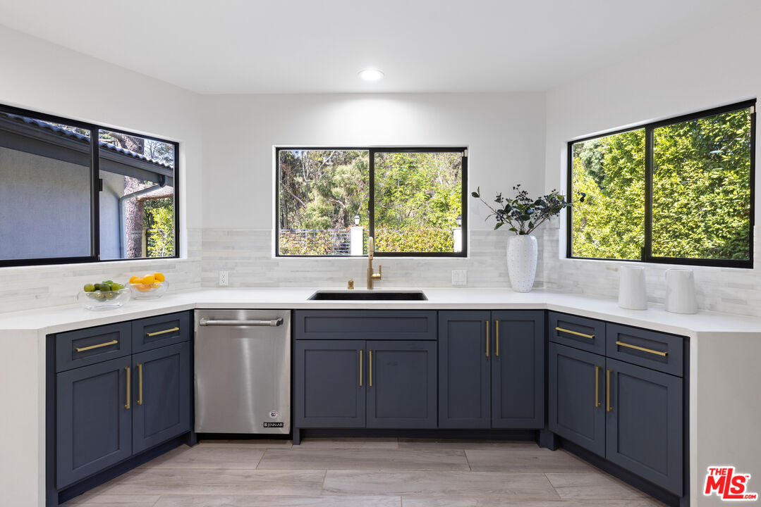 16167 Meadowcrest Road Sherman Oaks, CA 91403 - Photo 7 of 31 a kitchen with a sink window and cabinets