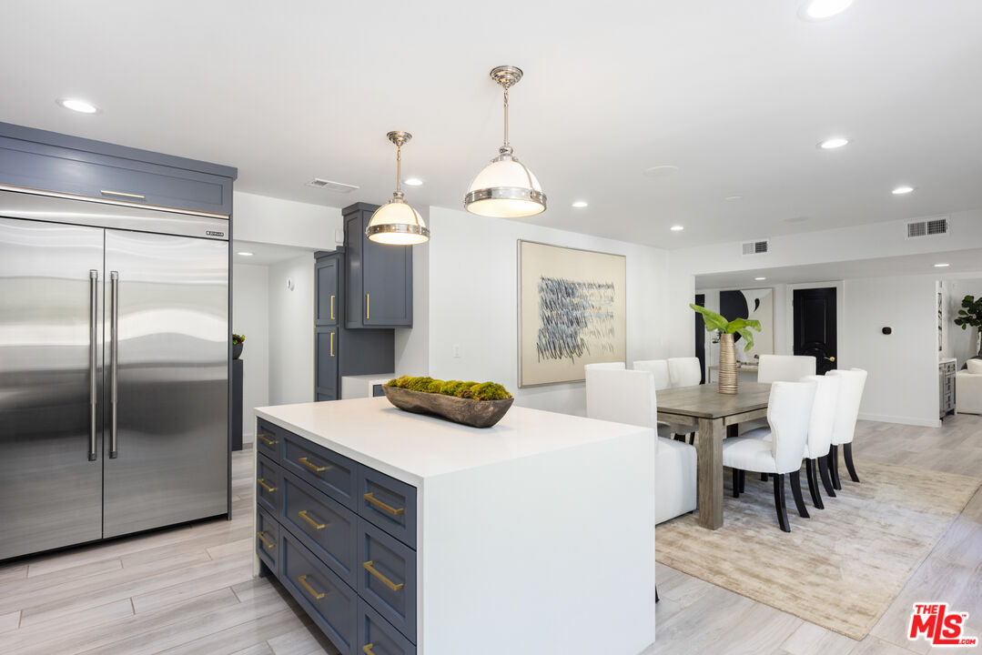 16167 Meadowcrest Road Sherman Oaks, CA 91403 - Photo 8 of 31 a kitchen with a refrigerator and a dining table