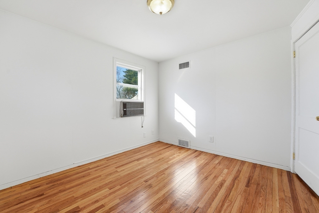 744 Bradley Road Springfield, MA 01109 - Photo 18 of 41 an empty room with wooden floor and windows