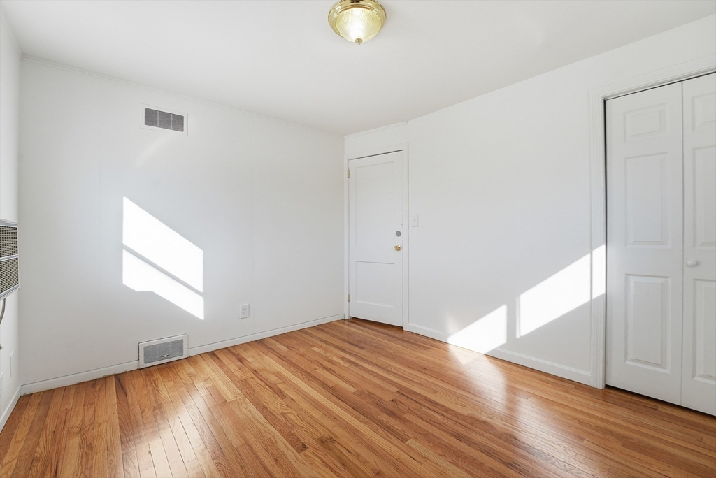 744 Bradley Road Springfield, MA 01109 - Photo 19 of 41 an empty room with wooden floor and windows