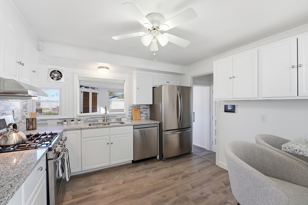744 Bradley Road Springfield, MA 01109 - Photo 9 of 41 a kitchen with stainless steel appliances granite countertop a refrigerator a sink dishwasher a stove and white cabinets with wooden floor