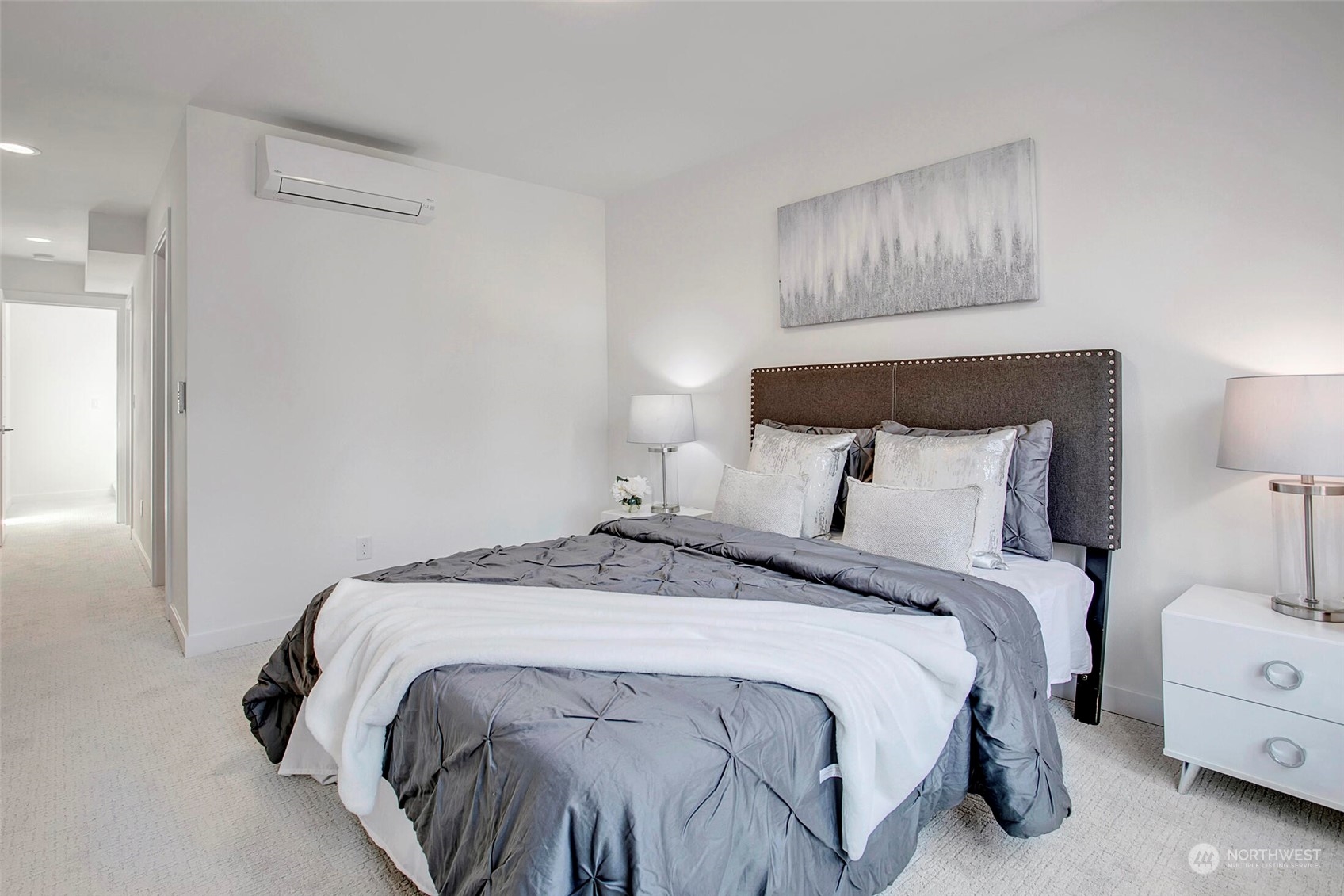 10170 Holman Road Northwest, Unit G Seattle, WA 98133 - Photo 14 of 23 a bed sitting in a bedroom next to a lamp