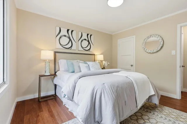 a bedroom with a bed and wooden floor