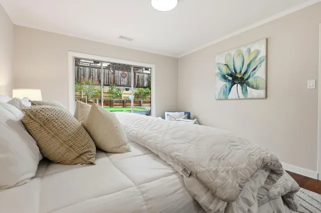 a large bed sitting in a bedroom next to a window