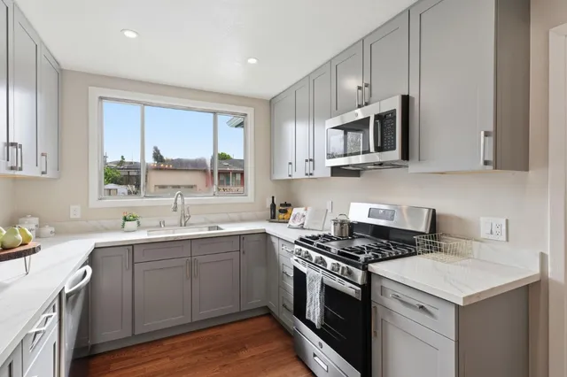 a kitchen with stainless steel appliances granite countertop a sink stove and microwave