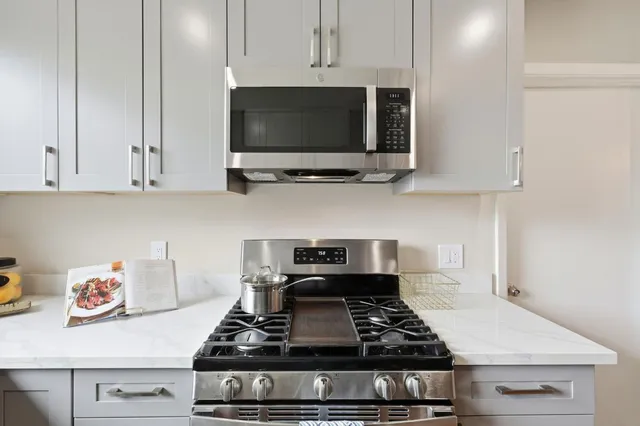 a stove top oven sitting inside of a kitchen