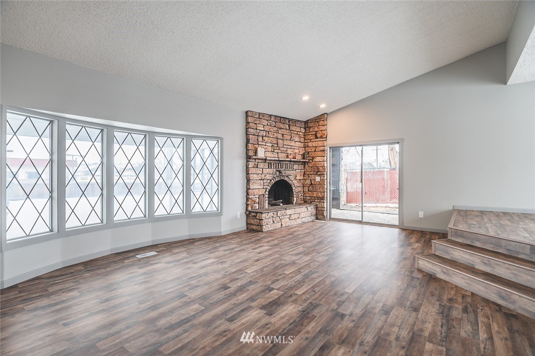 8037 Valley Road Northeast Moses Lake, WA 98837 - Photo 13 of 39 a view of empty room with wooden floor and fireplace