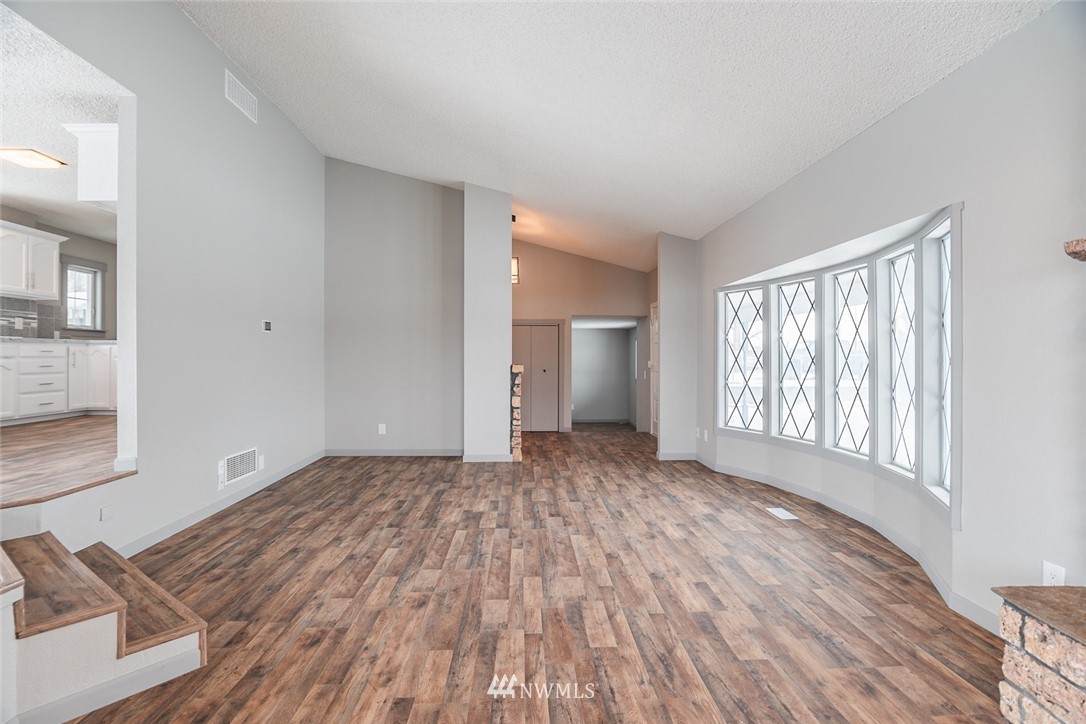8037 Valley Road Northeast Moses Lake, WA 98837 - Photo 14 of 39 a view of an empty room with wooden floor and a window