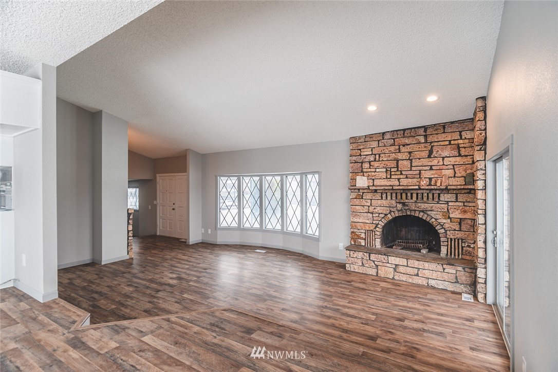 8037 Valley Road Northeast Moses Lake, WA 98837 - Photo 16 of 39 a view of an empty room with wooden floor fireplace and a window