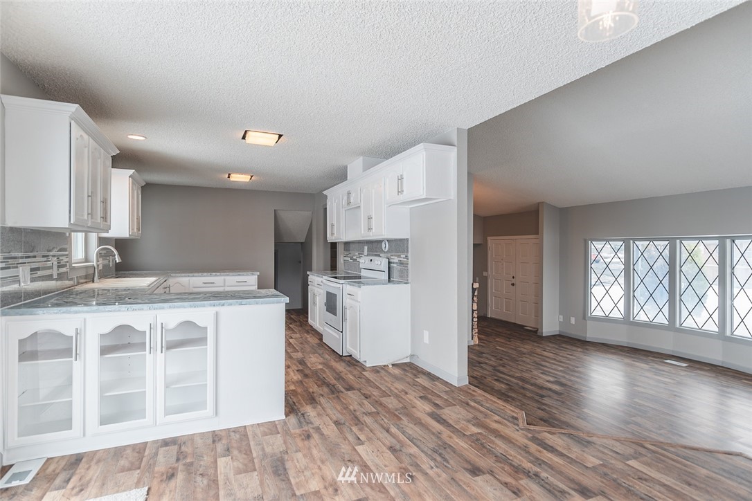 8037 Valley Road Northeast Moses Lake, WA 98837 - Photo 21 of 39 a kitchen with stainless steel appliances granite countertop a stove a sink and a refrigerator
