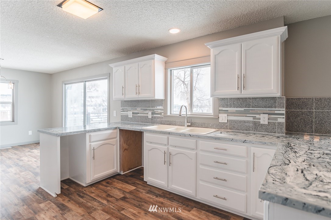 8037 Valley Road Northeast Moses Lake, WA 98837 - Photo 23 of 39 a kitchen with granite countertop white cabinets and white appliances