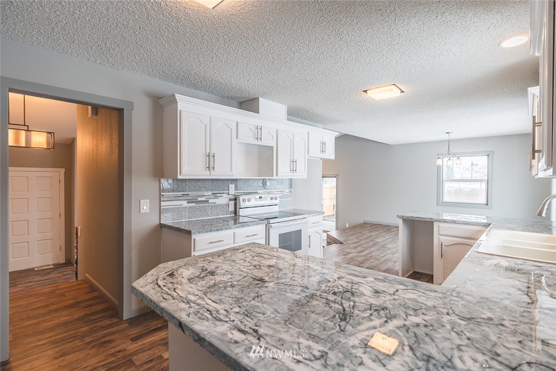 8037 Valley Road Northeast Moses Lake, WA 98837 - Photo 24 of 39 a kitchen with a stove a sink and a refrigerator