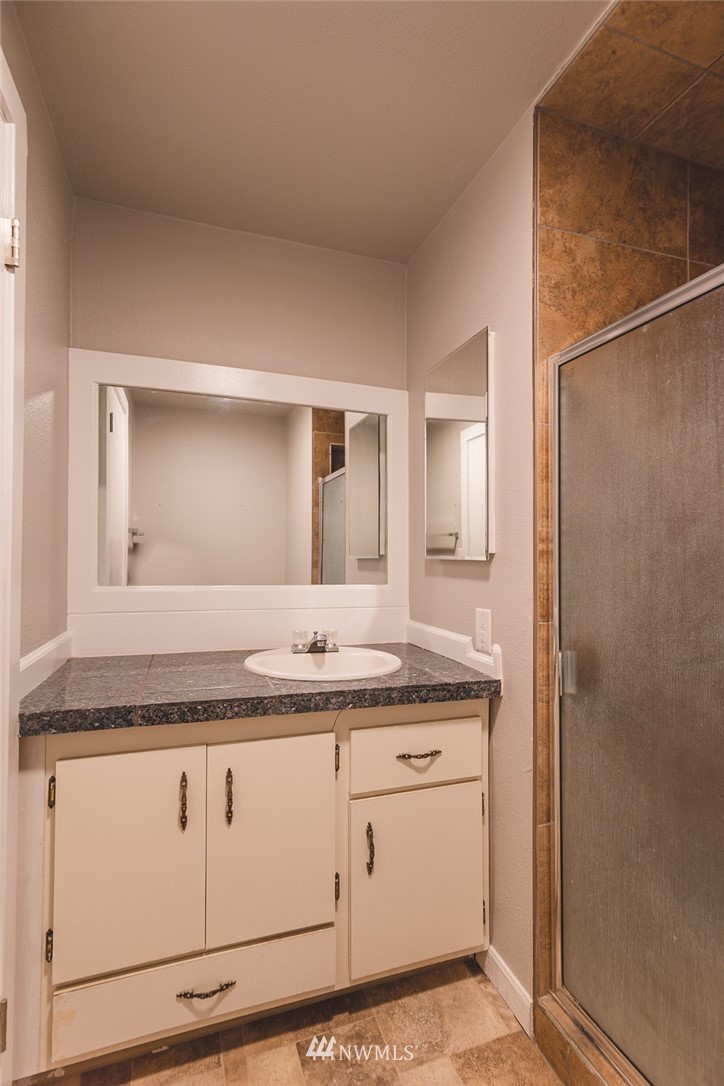 8037 Valley Road Northeast Moses Lake, WA 98837 - Photo 38 of 39 a bathroom with a granite countertop sink and a mirror