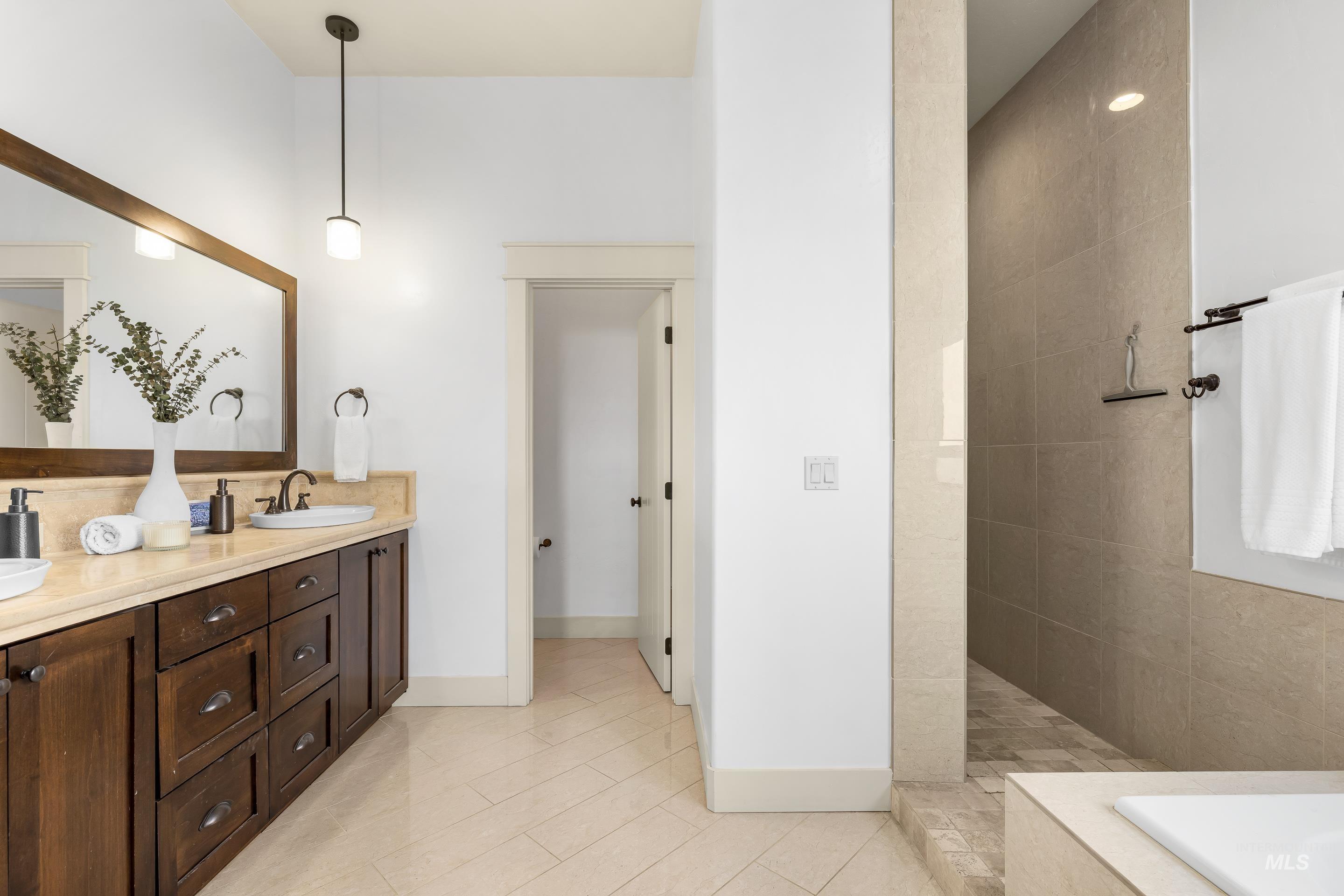 7521 North Grand Ridge Lane Eagle, ID 83616 - Photo 32 of 50 Full bathroom featuring double vanity, walk in shower, tiled bath, and light tile patterned floors