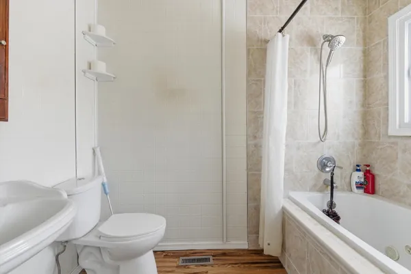 a bathroom with a sink a toilet and shower