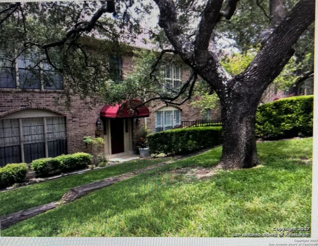 a view of a house with a tree in a yard