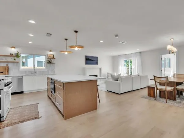 a large living room with stainless steel appliances kitchen island granite countertop furniture and a view of kitchen