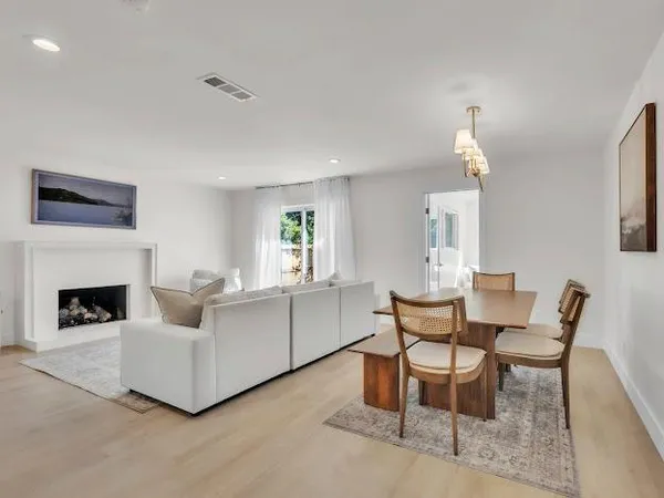a living room with furniture a fireplace and a large window