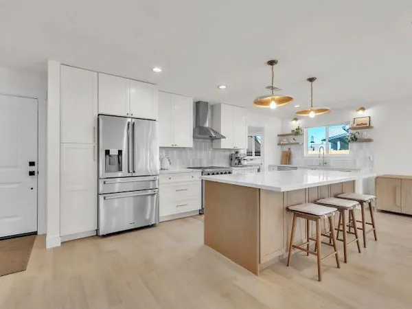 a kitchen with kitchen island a sink stove and refrigerator