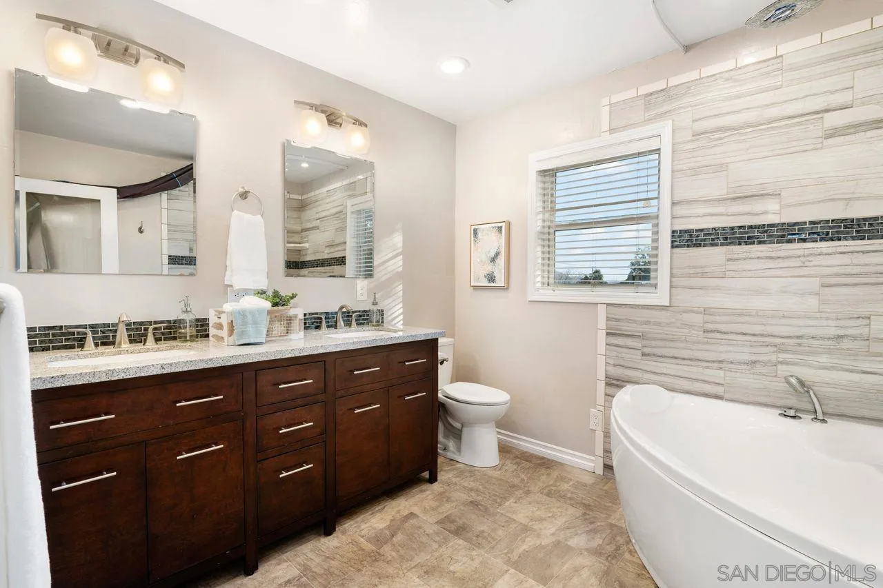 8601 Gardena Road Lakeside, CA 92040 - Photo 18 of 25 a bathroom with a tub sink toilet a mirror and a window