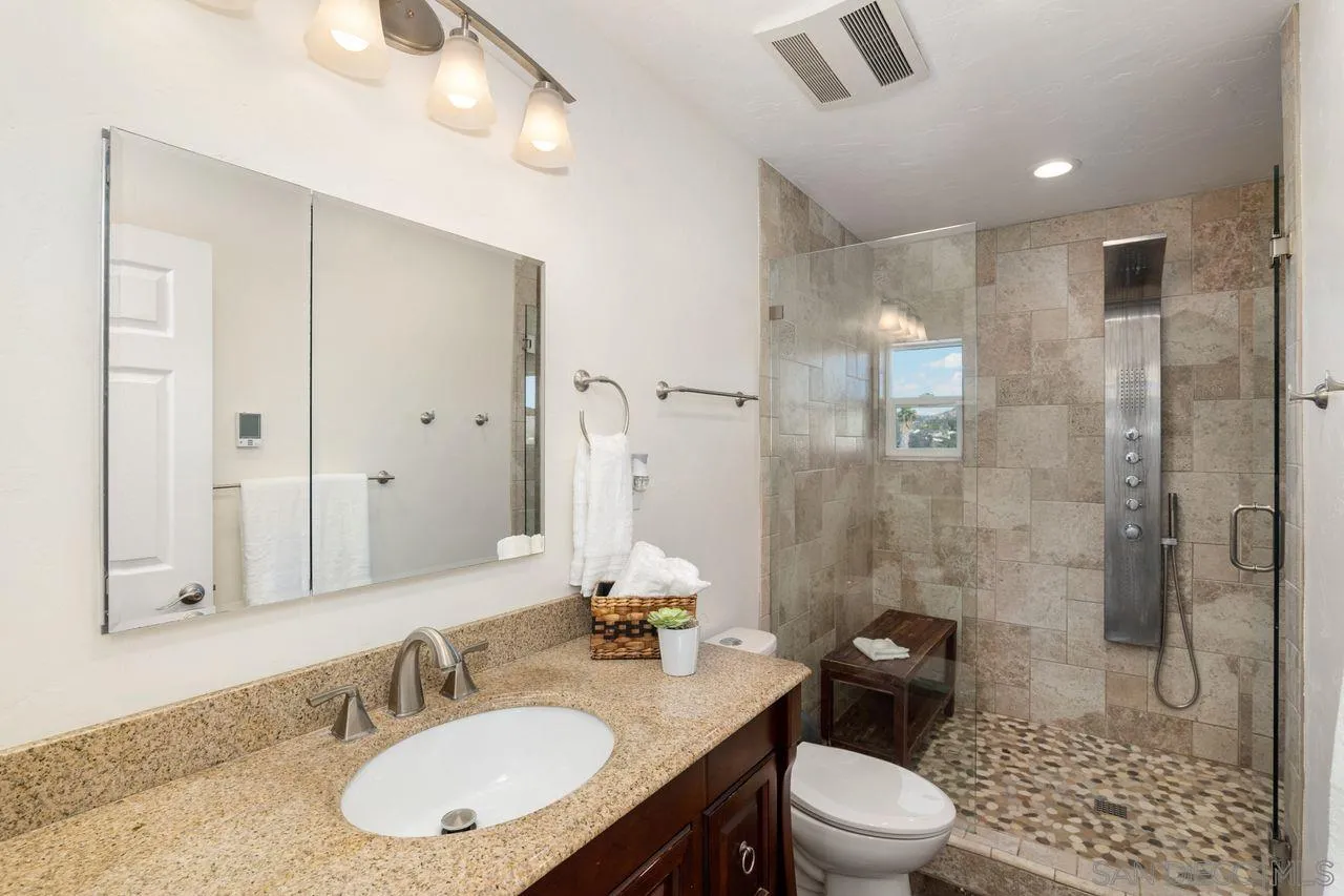 8601 Gardena Road Lakeside, CA 92040 - Photo 7 of 25 a bathroom with a granite countertop sink toilet a mirror and shower