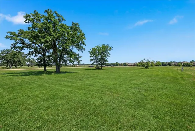 an aerial view of residential houses with outdoor space and trees