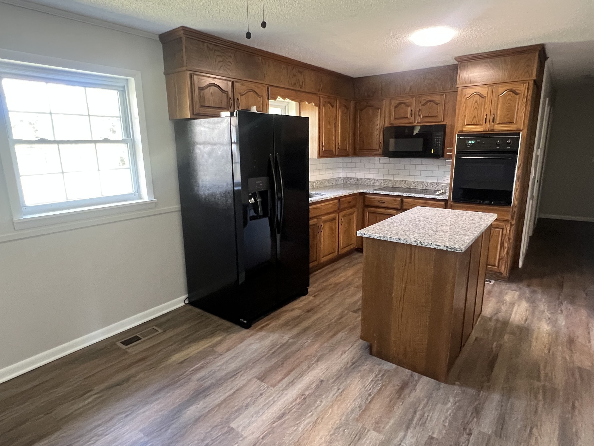 641 Coolidge Road Lafayette, TN 37083 - Photo 7 of 17 a kitchen with stainless steel appliances granite countertop a refrigerator a sink and wooden floor