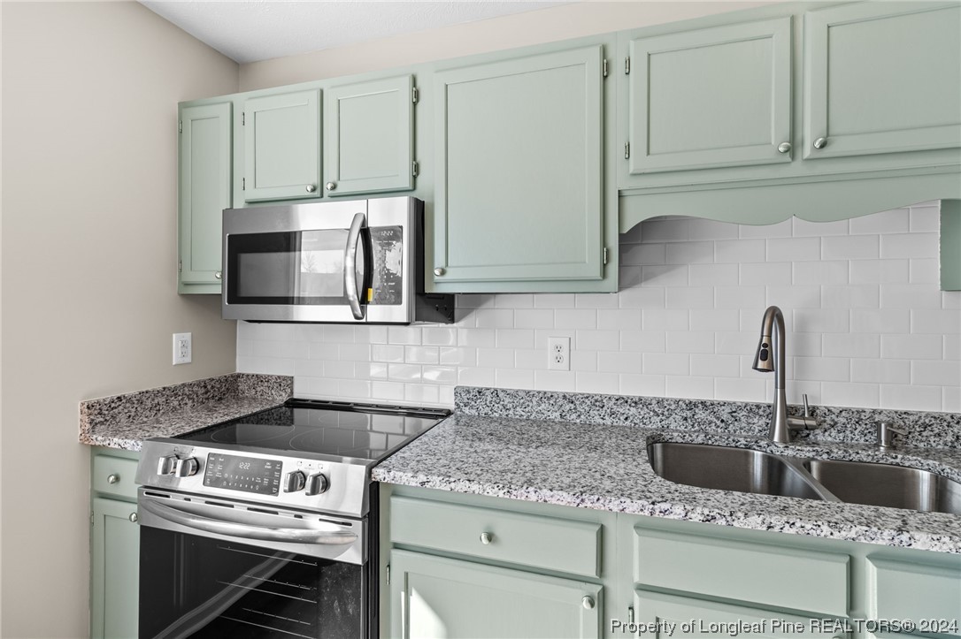 1030 Rim Road Fayetteville, NC 28314 - Photo 15 of 33 a kitchen with granite countertop a stove and a sink