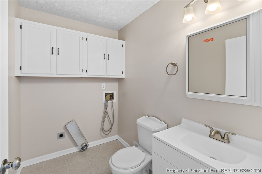 1030 Rim Road Fayetteville, NC 28314 - Photo 17 of 33 a bathroom with a toilet a sink and mirror