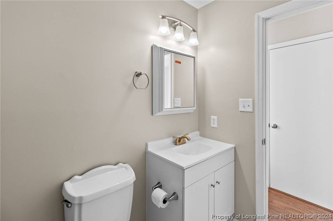 1030 Rim Road Fayetteville, NC 28314 - Photo 19 of 33 a bathroom with a toilet a sink and mirror
