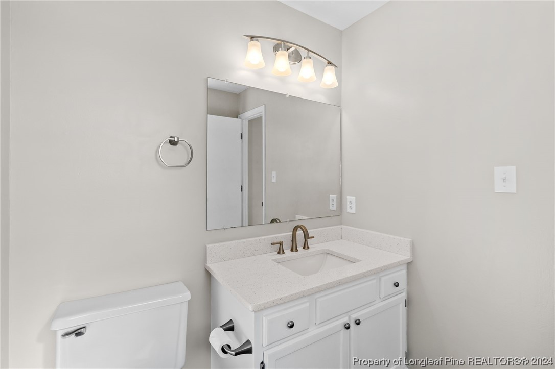 1030 Rim Road Fayetteville, NC 28314 - Photo 27 of 33 a bathroom with a sink a toilet and a mirror