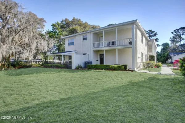 a view of a house with backyard and a tree