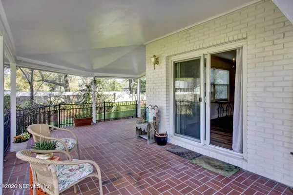 a living room with furniture floor to ceiling window and an outdoor view