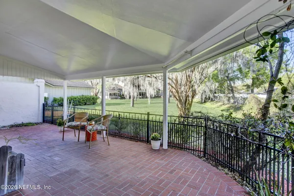 a view of a patio with a table chairs and a backyard