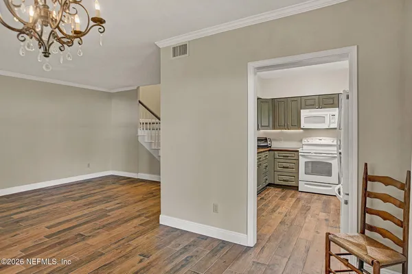 a view of staircase with wooden floor and white walls