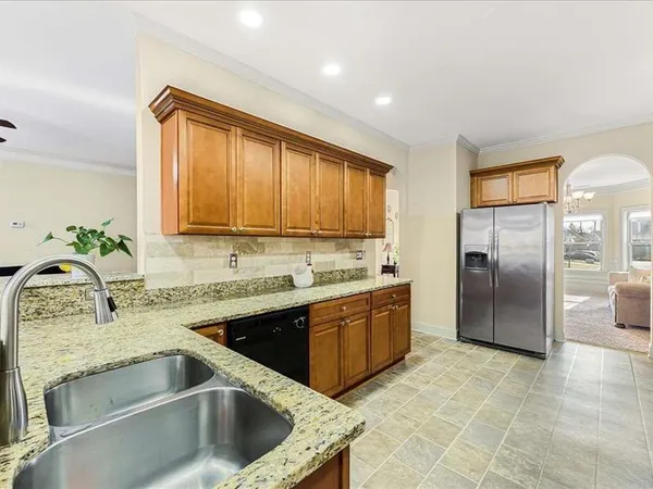 a kitchen with granite countertop a sink stainless steel appliances a counter top space and cabinets