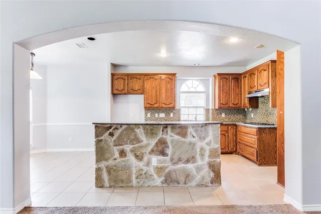 a bathroom with a granite countertop sink a bathtub and shower