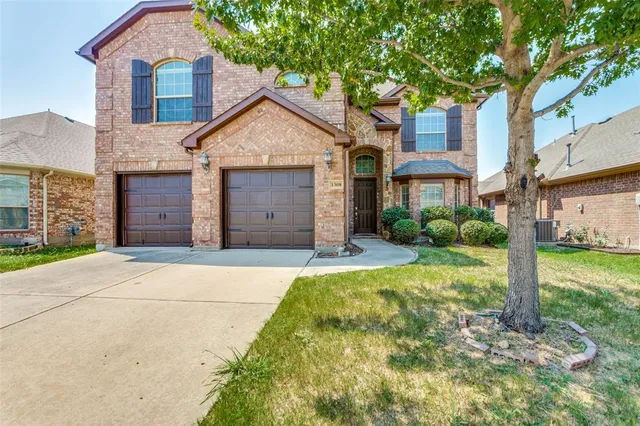 a view of a house with a yard and large tree