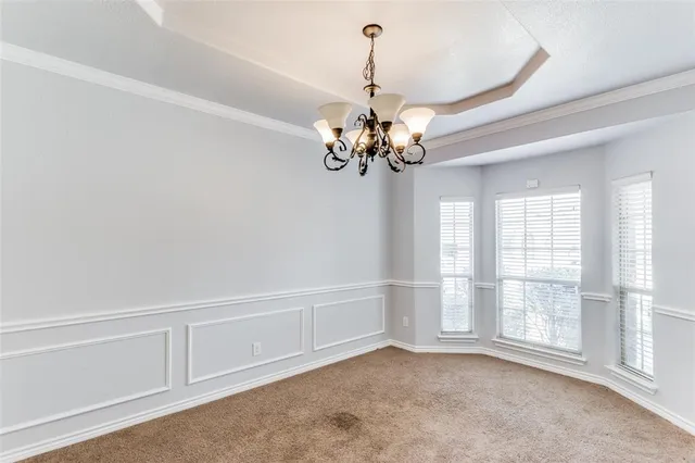 a view of a livingroom with a chandelier fan and windows