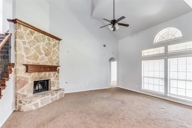 an empty room with windows and fireplace