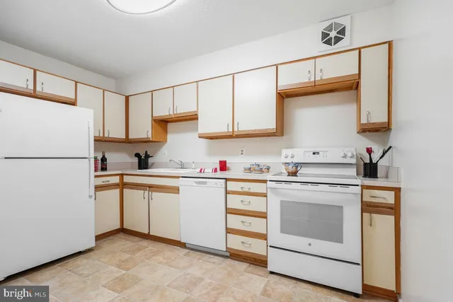 a kitchen with granite countertop white cabinets and white appliances