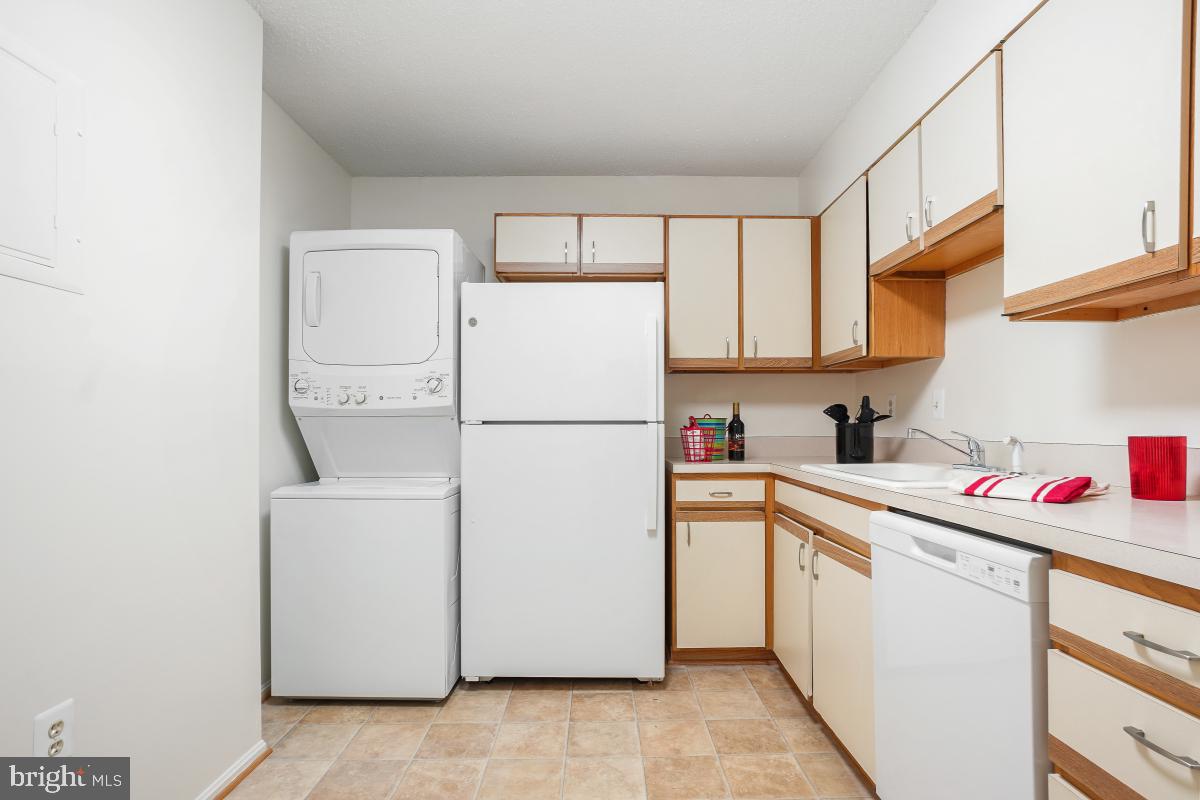 15107 Interlachen Drive, Unit 2321 Silver Spring, MD 20906 - Photo 20 of 35 a utility room with cabinets washer and dryer