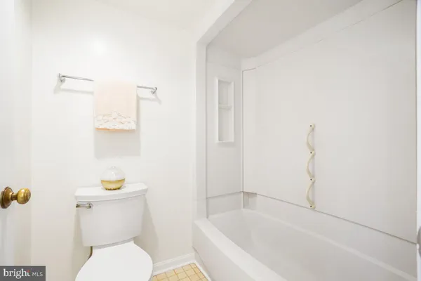 a white toilet sitting next to a bath tub