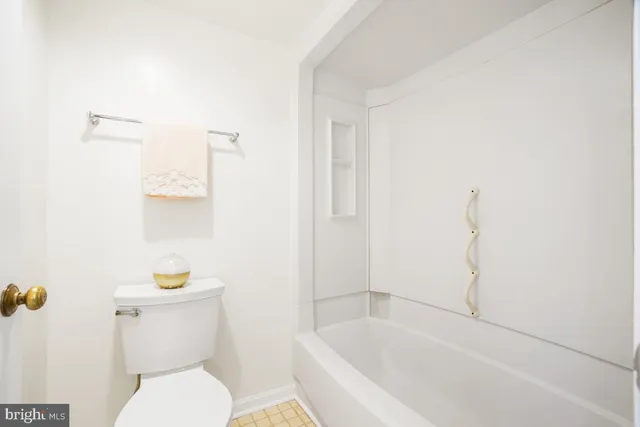 a white toilet sitting next to a bath tub
