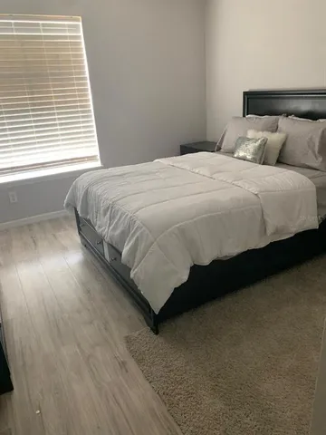 a bedroom with a bed and a night stand
