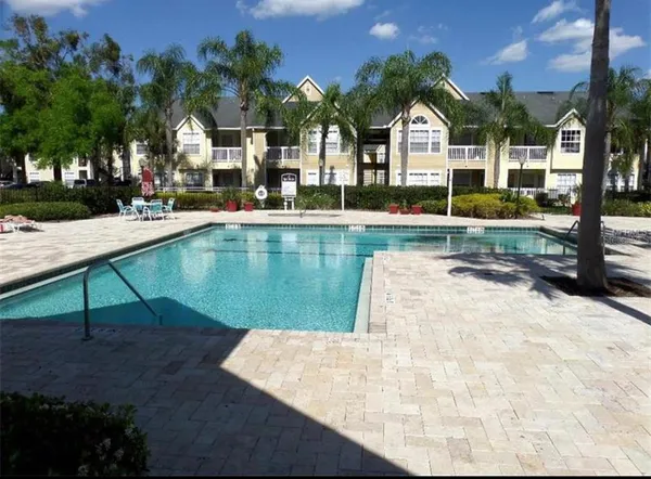 a view of swimming pool with outdoor seating and house in the background