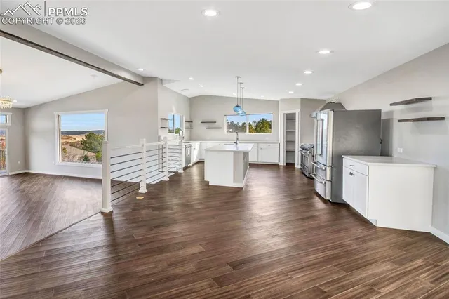 a kitchen with stainless steel appliances a sink stove and wooden floor