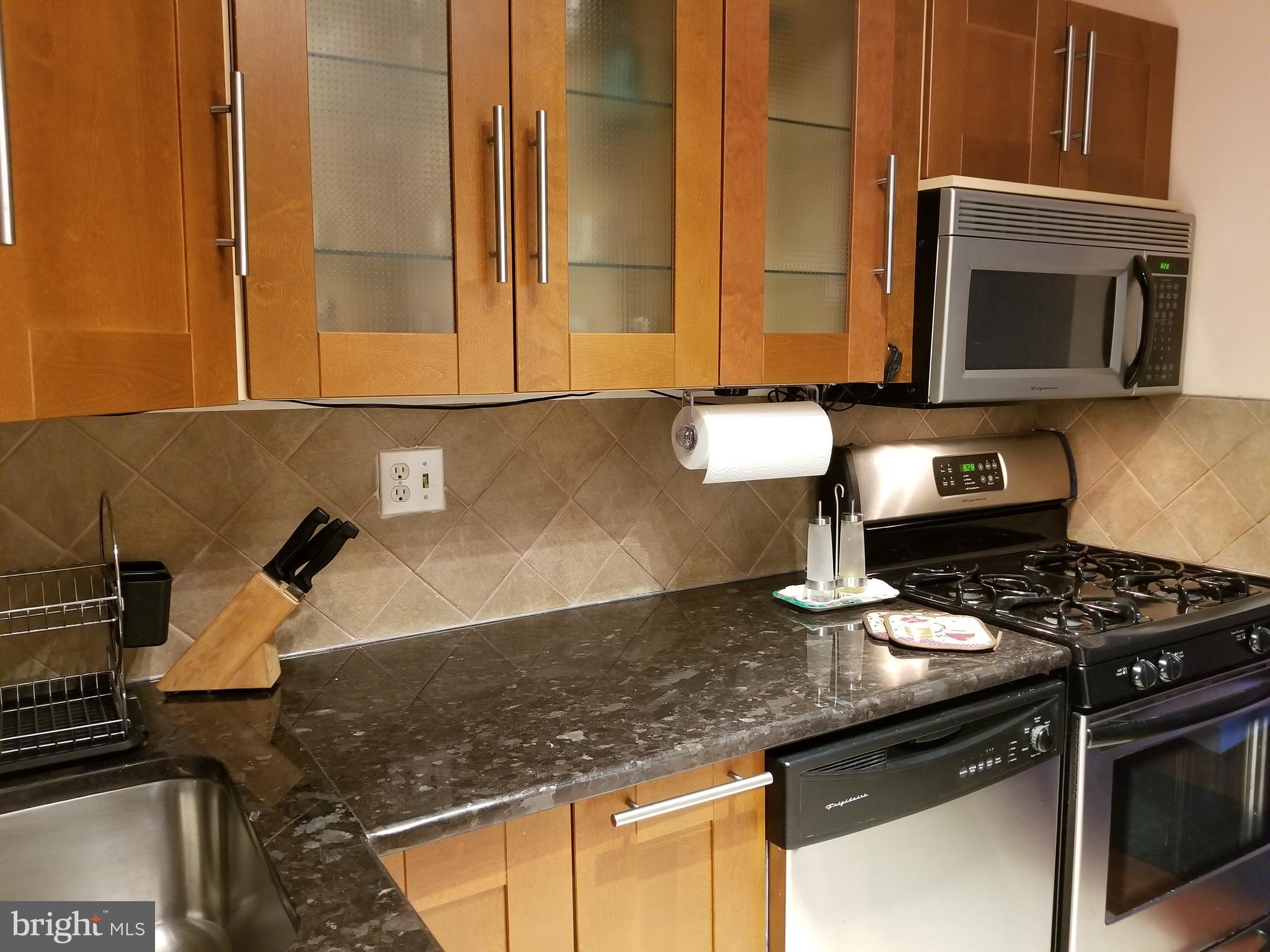 a kitchen with granite countertop a stove and a microwave