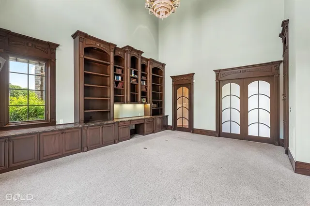 a view of an empty room with window and brick walls