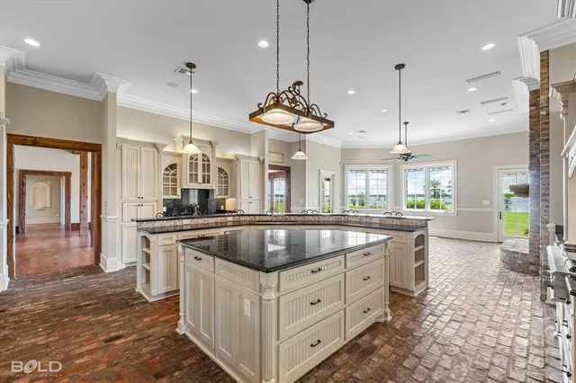 a kitchen with kitchen island granite countertop a sink a counter top space and stainless steel appliances